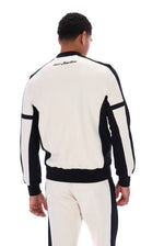 A man shown from the back wearing a black and off-white color-blocked track jacket and matching track pants against a plain white background.