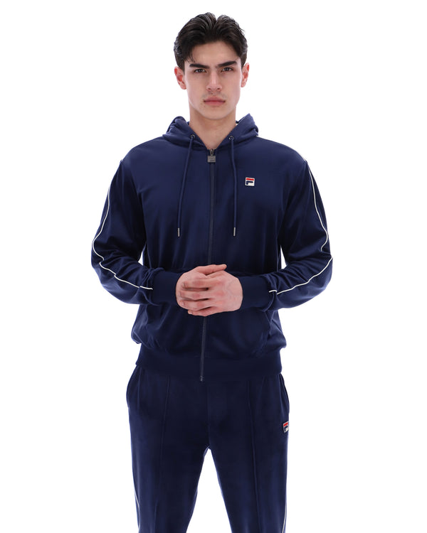 Displays a model wearing the Navy 'Fila' branded Italo Velour Hoodie
