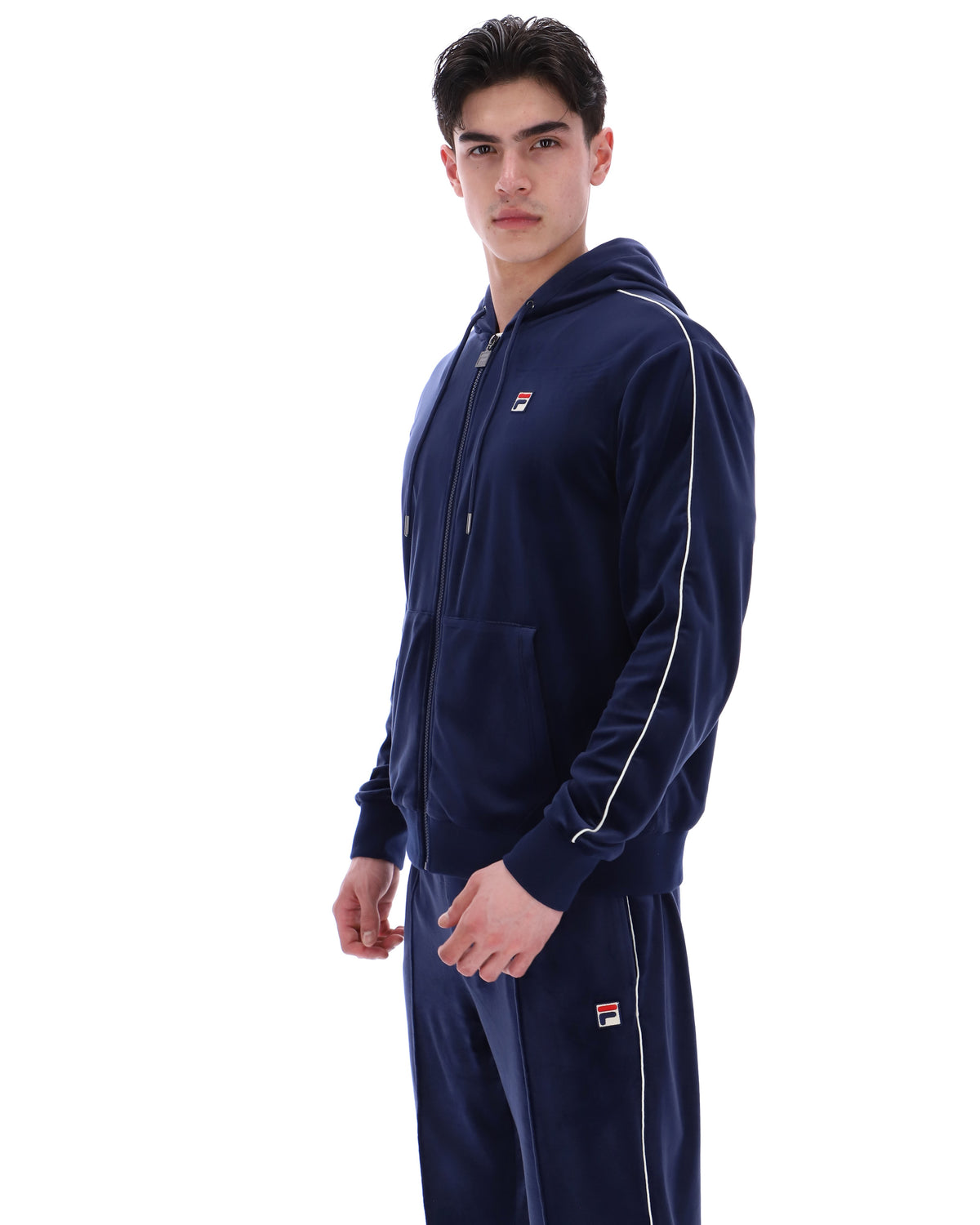 Displays a model wearing the Navy 'Fila' branded Italo Velour Hoodie