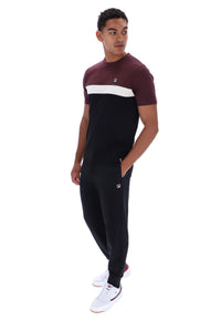 A man modeling a colorblock short-sleeve t-shirt and matching joggers. The t-shirt features a maroon upper chest and shoulders, a white horizontal stripe across the chest, and a black lower body.