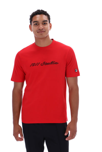 A man wearing a bright red short-sleeve t-shirt with '1911 Italia' printed in black script across the chest and a small Fila logo on the sleeve, set against a plain white background.