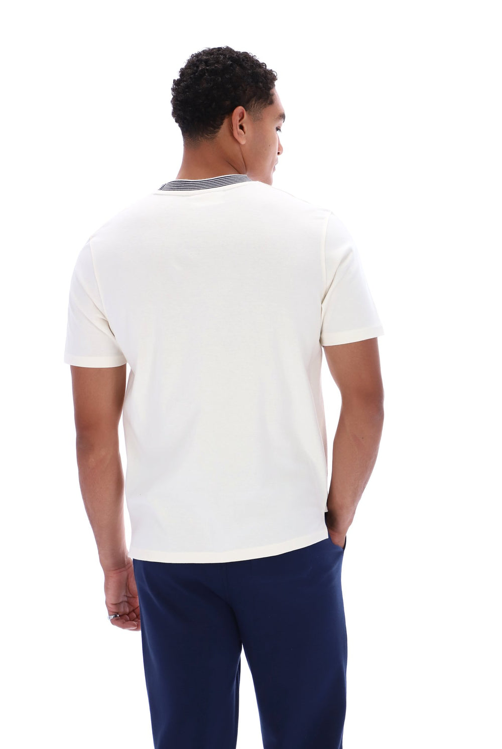 A man viewed from the back wearing a white short-sleeve t-shirt with a contrasting gray crew neck collar, paired with navy blue pants, against a plain white background.