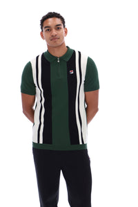 A man wearing a green, black, and white striped knit polo vest with a small red and white Fila logo on the chest, paired with black pants, against a plain white background.