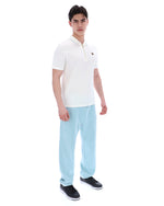 Man wearing a white polo shirt and light blue pants on a white background