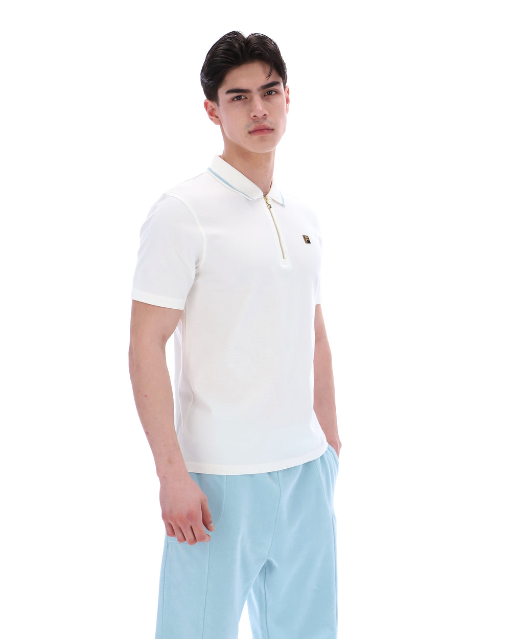 Man wearing a white polo shirt and light blue pants on a white background