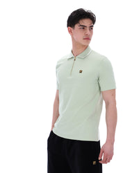 Person wearing a light green polo shirt with a brand logo on a white background