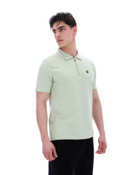 Man wearing a light green polo shirt on a white background