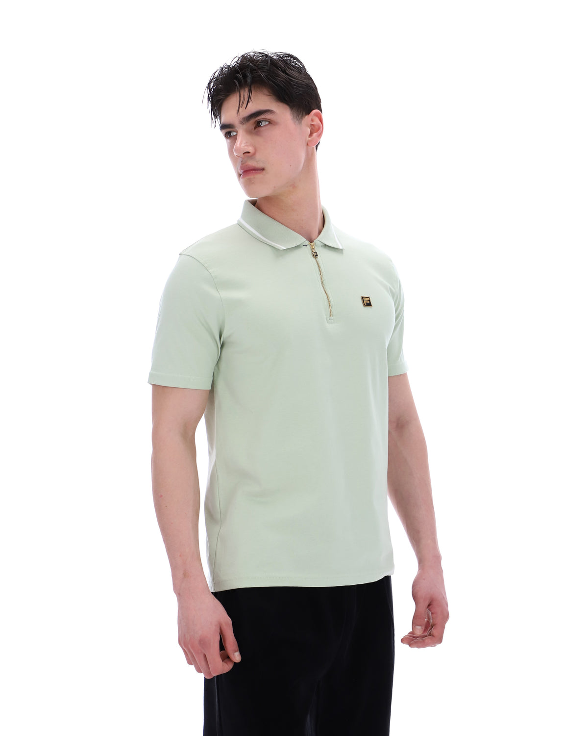 Man wearing a light green polo shirt on a white background