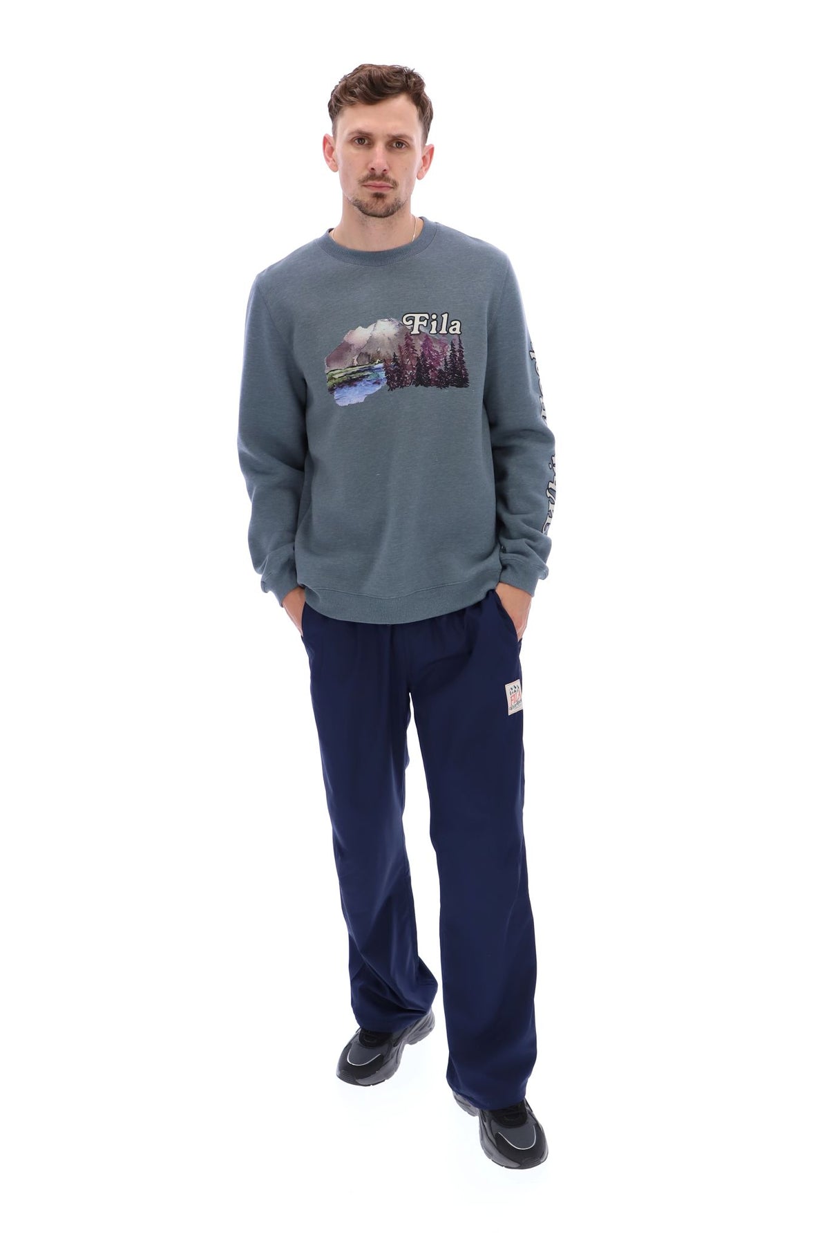 Displays a model wearing the Stormy Weather 'FILA' branded Len Graphic Crew Sweatshirt