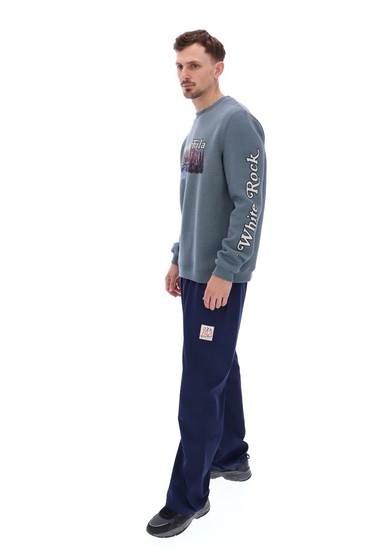 Displays a model wearing the Stormy Weather 'FILA' branded Len Graphic Crew Sweatshirt