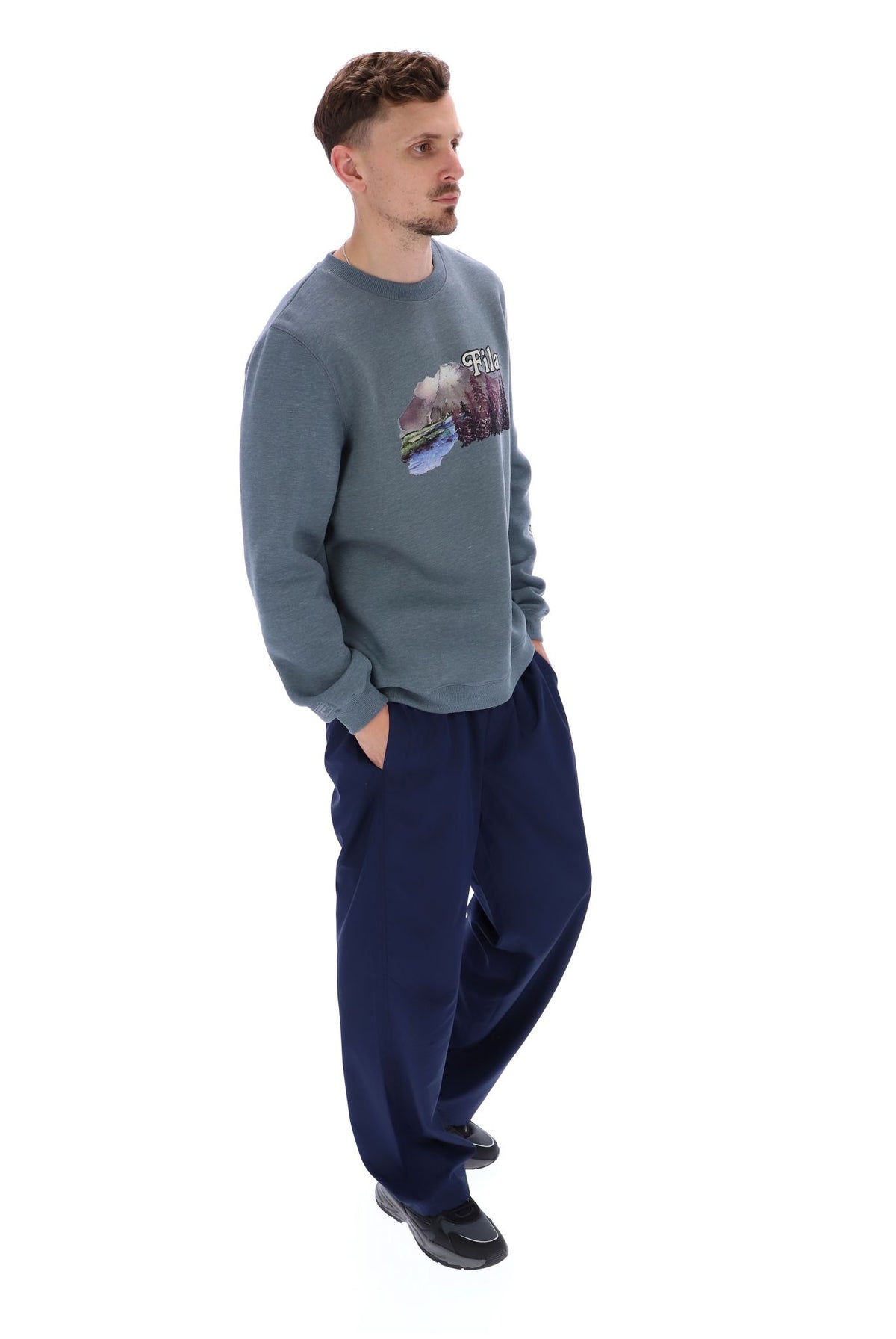 Displays a model wearing the Stormy Weather 'FILA' branded Len Graphic Crew Sweatshirt