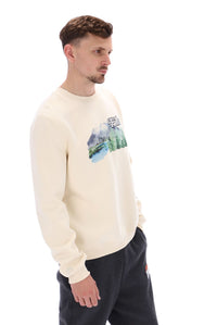 A male model wearing a beige FILA Len Graphic Crew Sweatshirt with a mountain range and brand logo on the front.