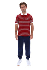 A man modeling a red and white striped short-sleeve polo shirt with a white collar, paired with navy blue jogger pants and white sneakers, against a plain white background.