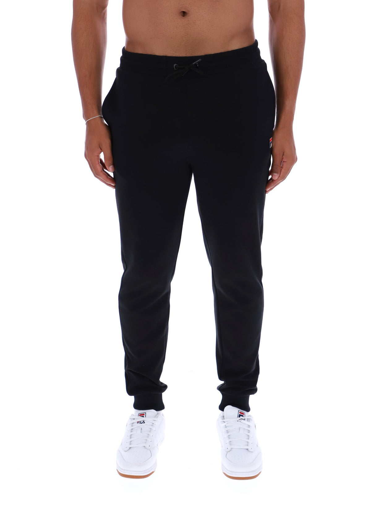 Person wearing black jogger pants on a white background