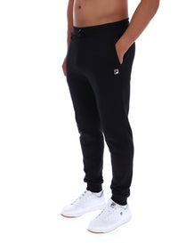 Person wearing black jogger pants with a brand logo on a white background