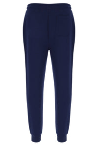 A person standing and wearing navy blue Lonny drawstring joggers with a drawstring waistband and cuffed design, featuring FILA logo branded on the waistband.