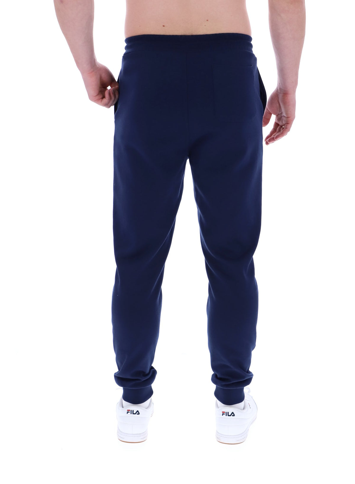 A person standing and wearing navy blue Lonny drawstring joggers with a drawstring waistband and cuffed design, featuring FILA logo branded on the waistband.