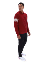 A man modeling a red long-sleeve quarter-zip pullover sweatshirt with white stripes on the sleeves, paired with black pants and white sneakers, against a plain white background.