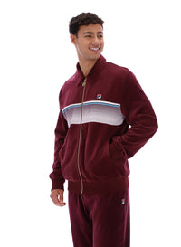 Man wearing a burgundy track top with a FILA logo, paired with matching bottoms, against a white background