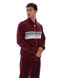 Man wearing a burgundy track top with a FILA logo, paired with matching bottoms, against a white background
