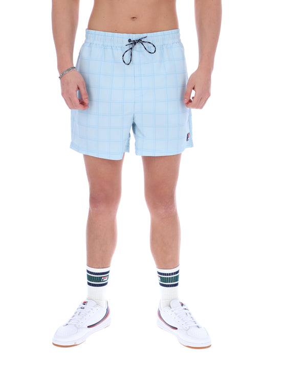Person wearing light blue checkered shorts on a white background
