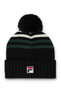 A black knit pom-pom beanie with horizontal stripes in white and dark green, featuring a small embroidered Fila logo on the front cuff.