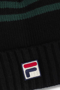 Close-up of a black ribbed knit beanie with dark green horizontal stripes near the top and a white embroidered Fila logo patch on the cuff.
