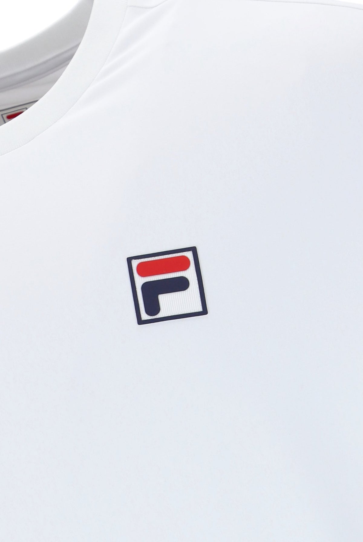 White tennis t-shirt with cap sleeves, featuring the FILA logo and a Union Jack flag patch on the chest.