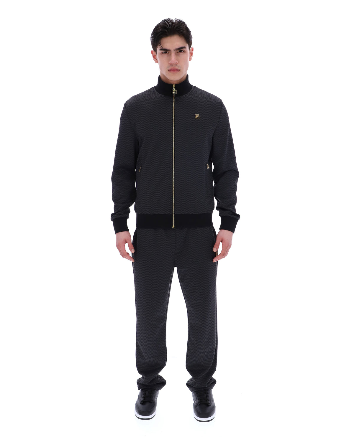 Displays a model wearing the Black 'FILA' branded Mathers Herringbone Track Top
