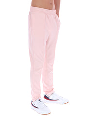 Person wearing light pink sweatpants and white sneakers on a white background