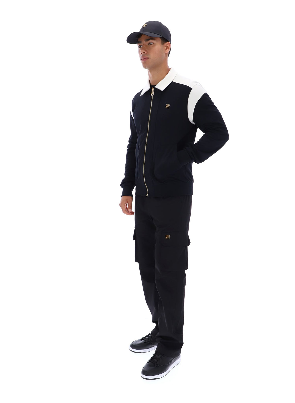 Man wearing a black tracksuit with white accents on a white background