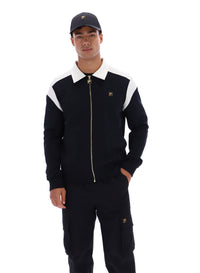 Man wearing a black tracksuit with white accents and a cap on a white background