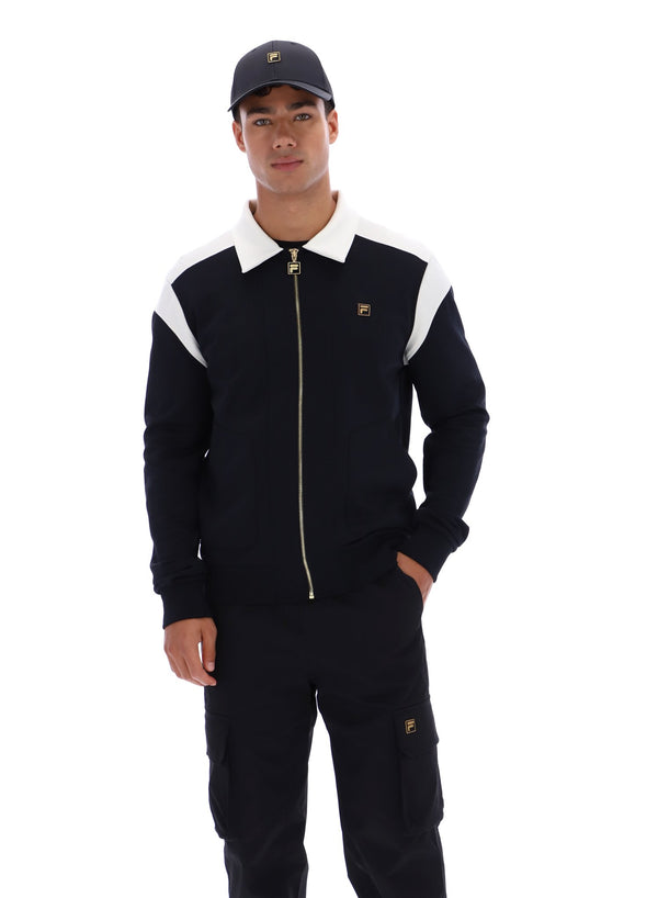 Man wearing a black tracksuit with white accents and a cap on a white background