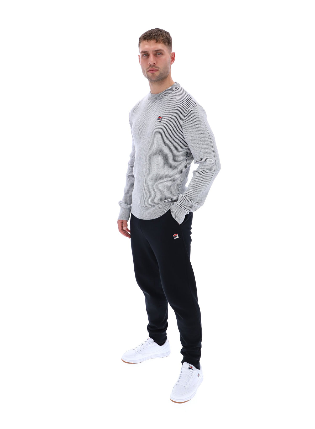 Displays a model wearing the Gardenia 'FILA' branded Noah Knitted Crew Neck