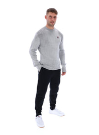 Displays a model wearing the Gardenia 'FILA' branded Noah Knitted Crew Neck