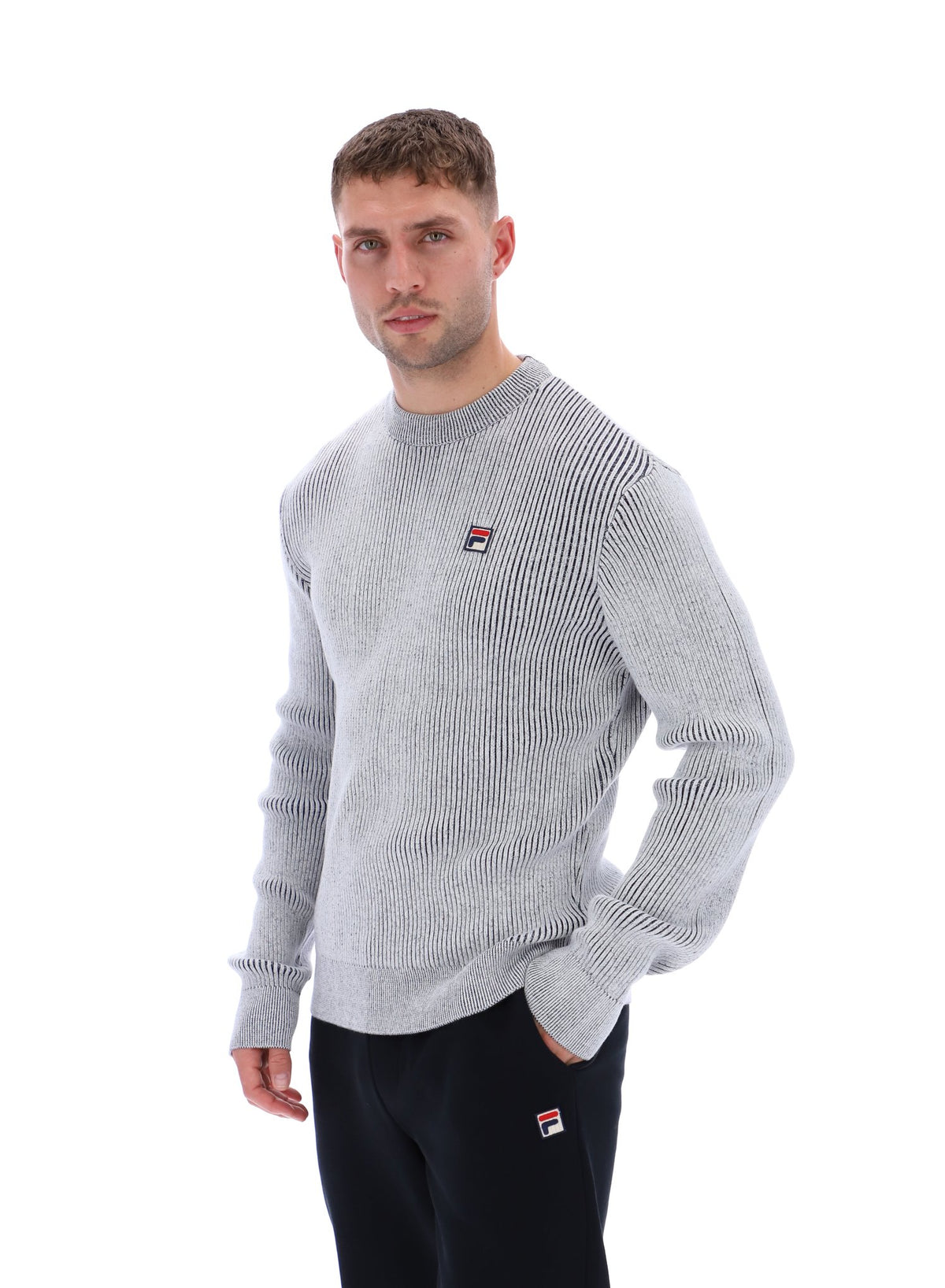 Displays a model wearing the Gardenia 'FILA' branded Noah Knitted Crew Neck