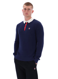Man wearing a navy sweater with a white collar and red accents on a white background