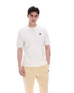 Man wearing a white t-shirt with a logo on a white background