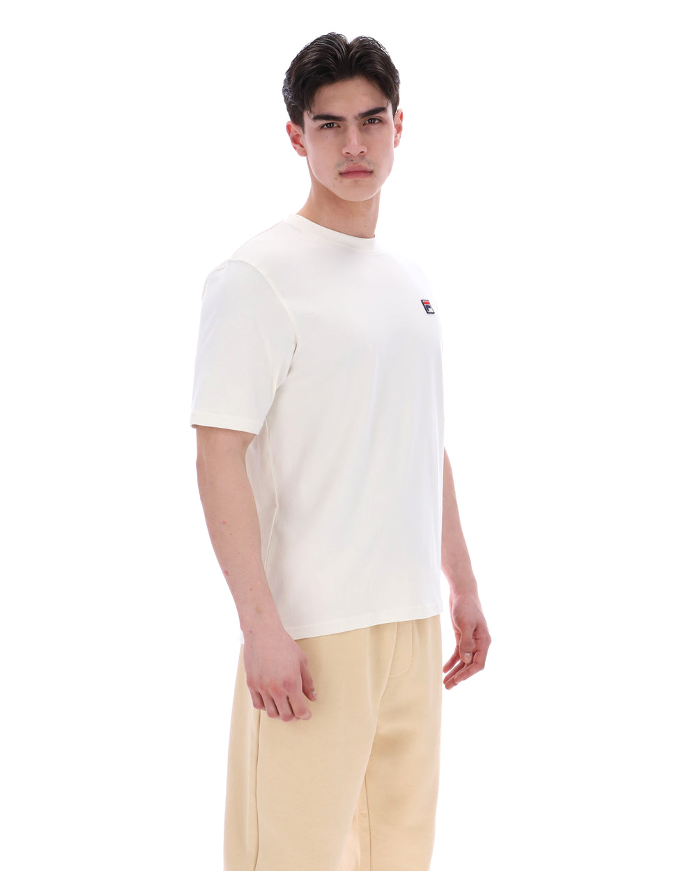 Man wearing a white t-shirt with a small logo on a white background