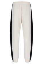 Off-white sweatpants with black side stripes, shown from the back against a plain white background.