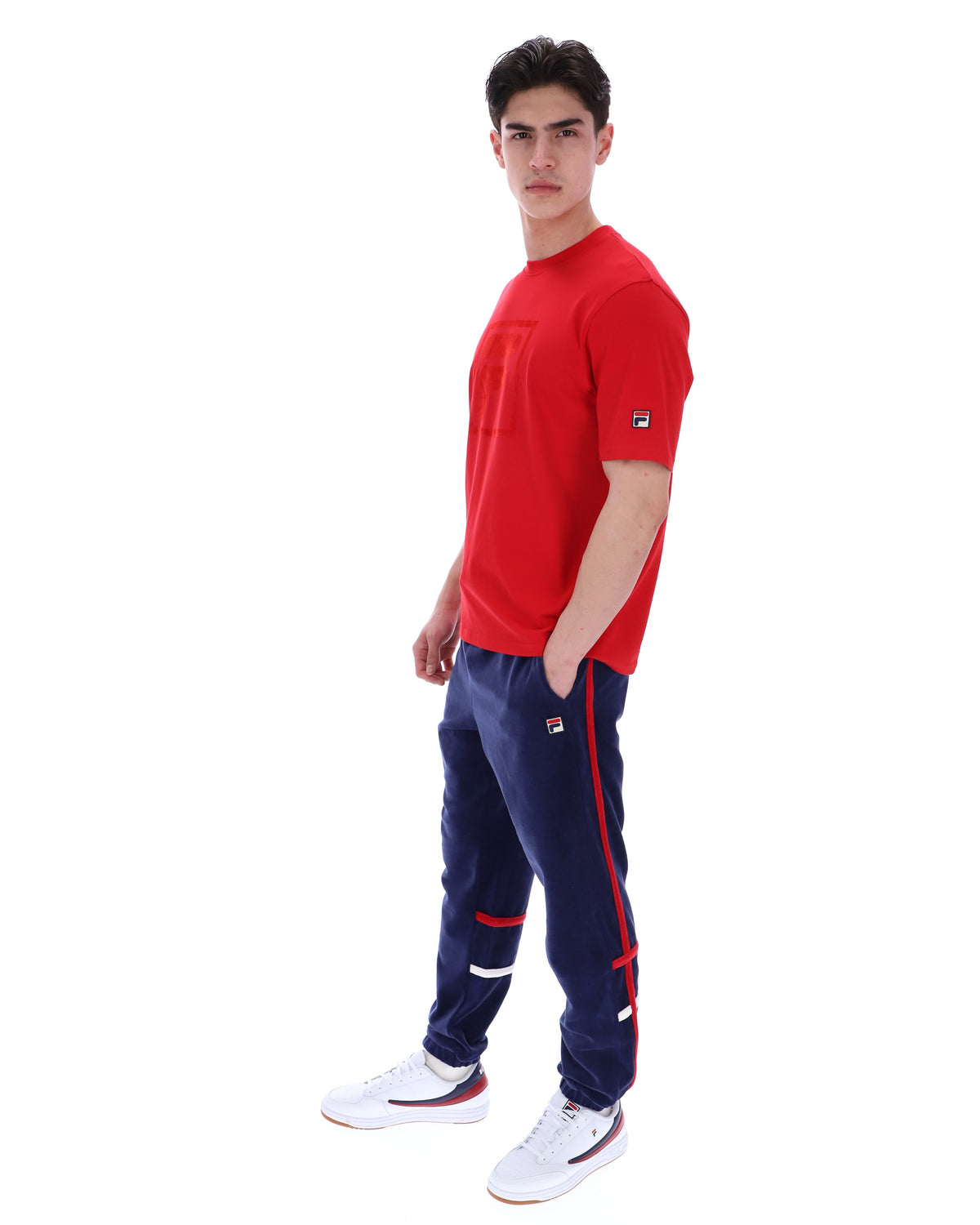 Man wearing a red shirt and blue pants with a white background