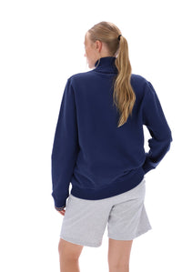 Woman wearing a navy quarter zip jumper, paired with grey FILA jogger shorts, against a white background