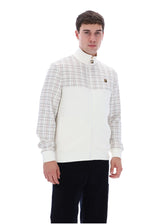 A man wearing a white and beige plaid zip-up jacket with a high collar, paired with black pants, photographed against a solid white background.
