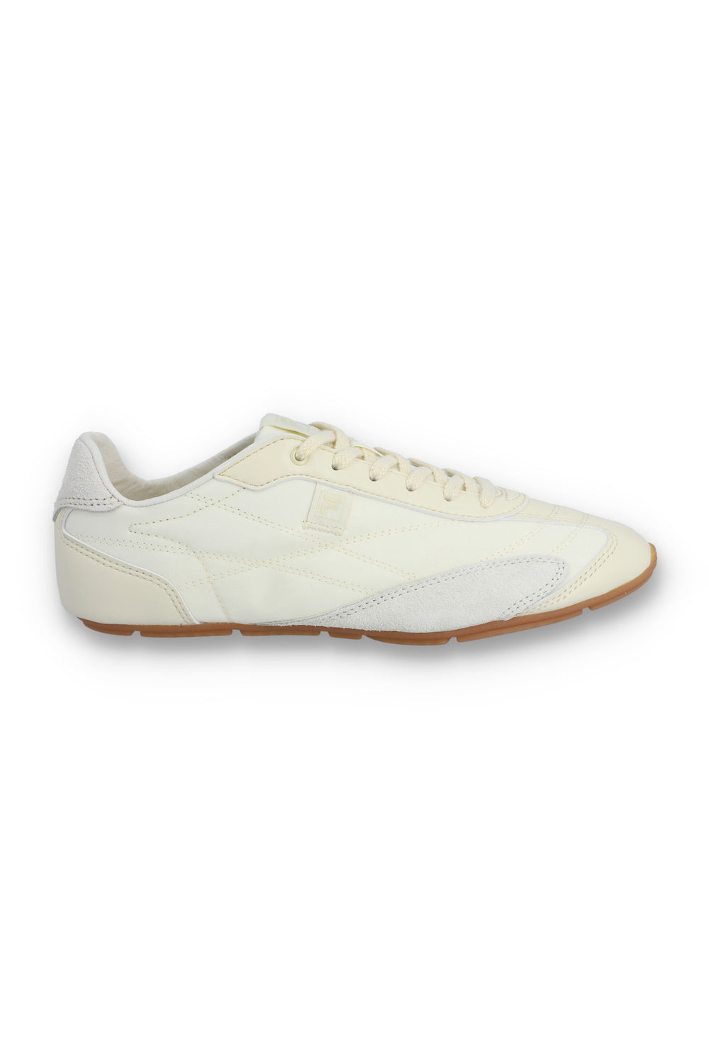 Profile view of a FILA Ritmo trainer in off-white nylon and suede, featuring a low-profile silhouette, tonal laces, an embroidered 'F' logo on the side panel, and a slim brown rubber sole against a white background.