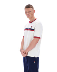 Man wearing a white t-shirt with red and blue accents and dark pants on a white background
