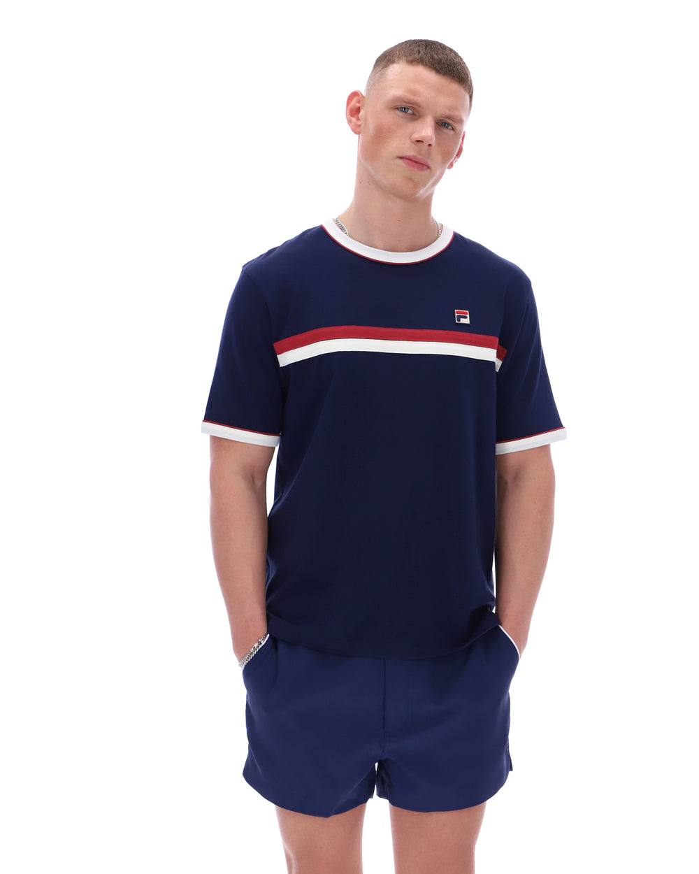 Man wearing a navy t-shirt with red and white stripes and matching shorts on a white background