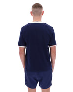 Man wearing a navy blue sports outfit with white trim on a white background