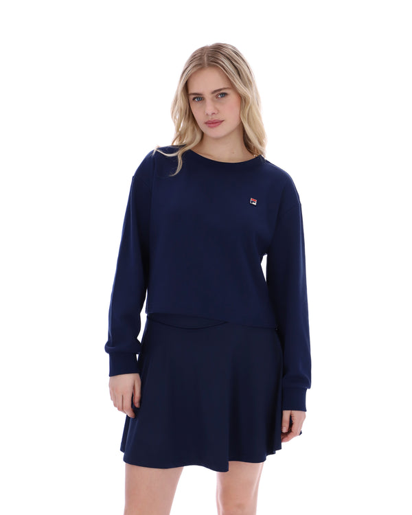 Woman wearing a navy blue sweatshirt and skirt set on a white background
