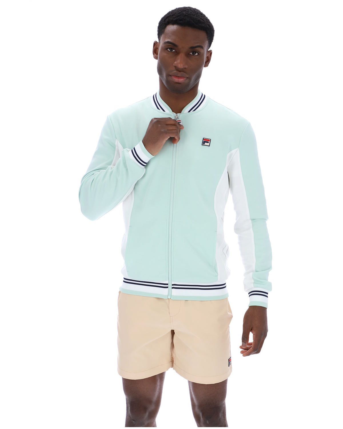 Man wearing a light blue tracksuit with a brand logo on a white background