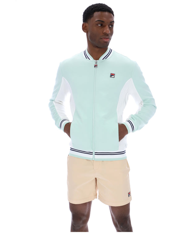 Man wearing a light blue tracksuit with a white background